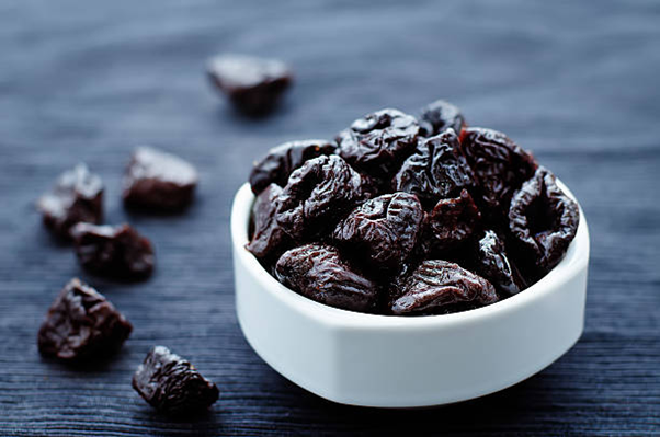 Mindful247 - A bowl of prunes for relieving constipation.